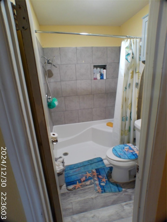 bathroom featuring hardwood / wood-style floors, curtained shower, and toilet