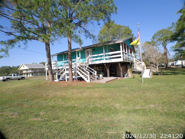 rear view of property featuring a deck and a yard