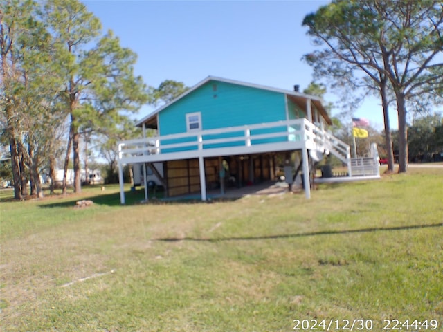 rear view of property featuring a deck and a lawn