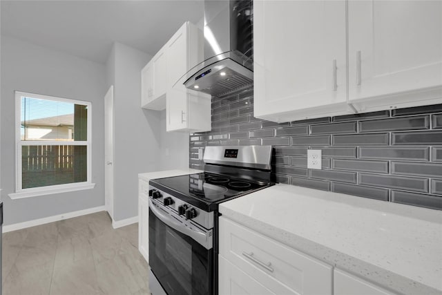 kitchen with light stone countertops, tasteful backsplash, wall chimney exhaust hood, white cabinets, and stainless steel range with electric cooktop