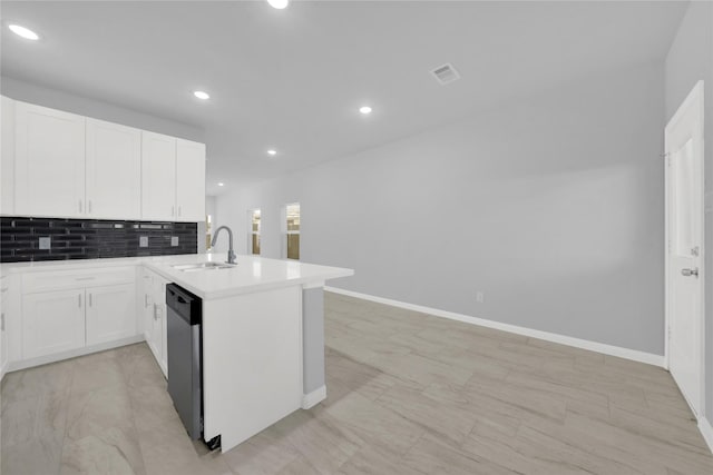 kitchen featuring kitchen peninsula, white cabinets, stainless steel dishwasher, and sink