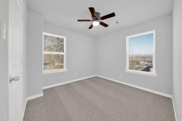 unfurnished room featuring a wealth of natural light, carpet floors, and ceiling fan