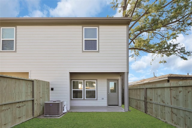 rear view of property with a patio, a lawn, and central air condition unit