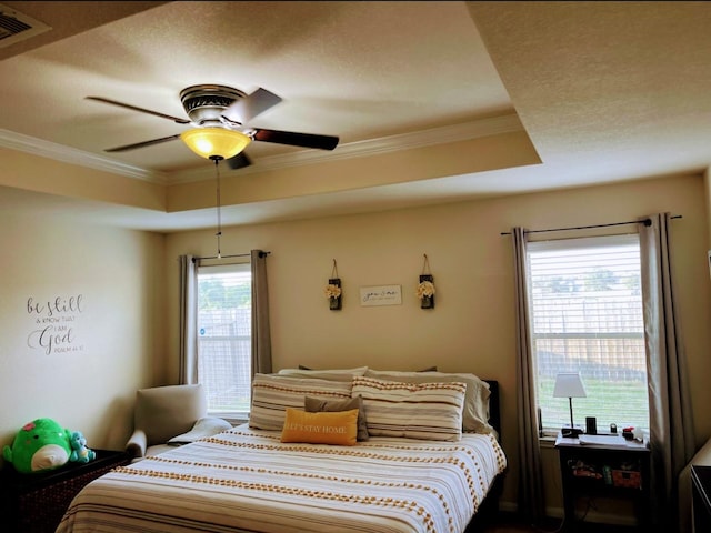 bedroom featuring a tray ceiling, ceiling fan, and ornamental molding