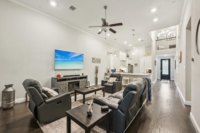 living room featuring ceiling fan with notable chandelier, wood-type flooring, and ornamental molding