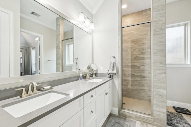 bathroom with crown molding, a shower with shower door, and vanity