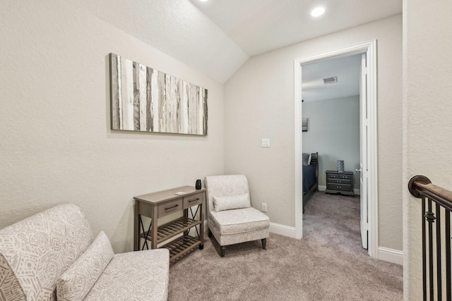 living area with light colored carpet and vaulted ceiling