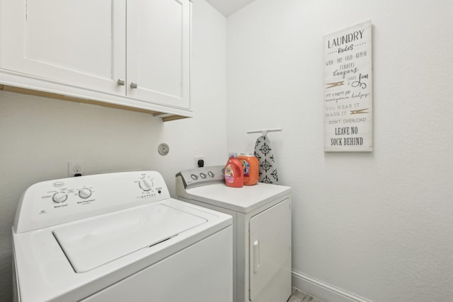 laundry room featuring washer and clothes dryer and cabinets