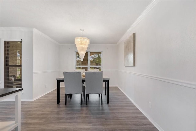 dining room featuring dark wood-type flooring, an inviting chandelier, and crown molding