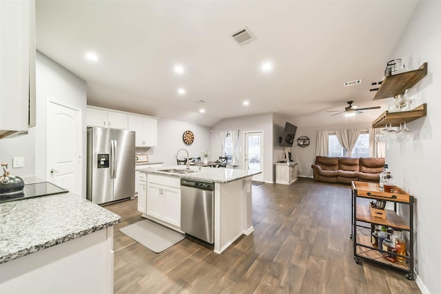 kitchen with a center island with sink, sink, appliances with stainless steel finishes, light stone counters, and white cabinetry