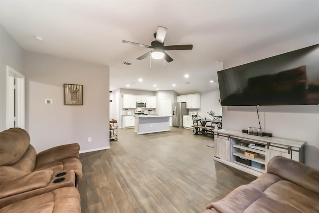 living room with ceiling fan and hardwood / wood-style floors