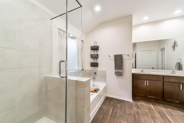 bathroom featuring vanity, plus walk in shower, wood-type flooring, and vaulted ceiling