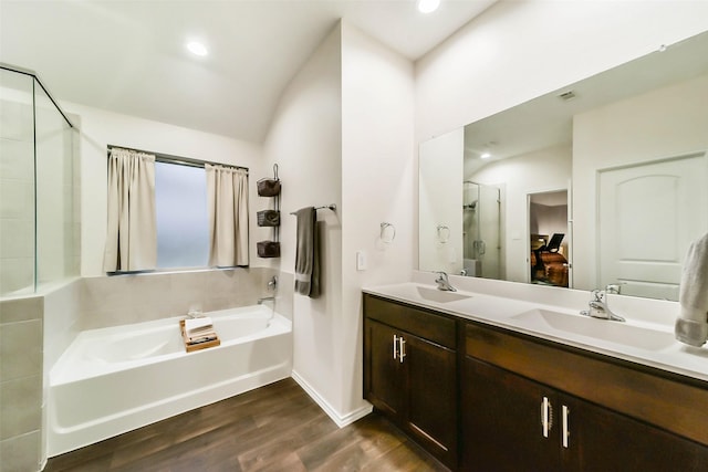 bathroom with hardwood / wood-style floors, vanity, and separate shower and tub