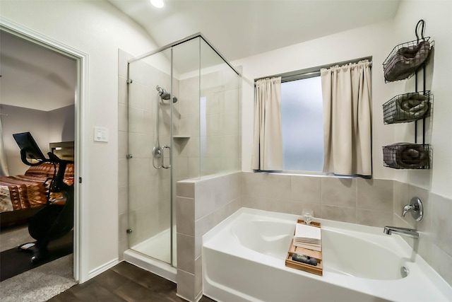 bathroom featuring shower with separate bathtub and wood-type flooring