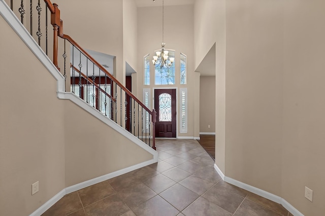 tiled entryway with a high ceiling and an inviting chandelier