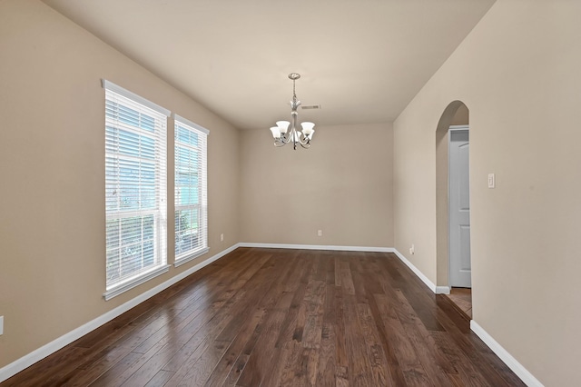 unfurnished dining area with dark hardwood / wood-style flooring and a notable chandelier