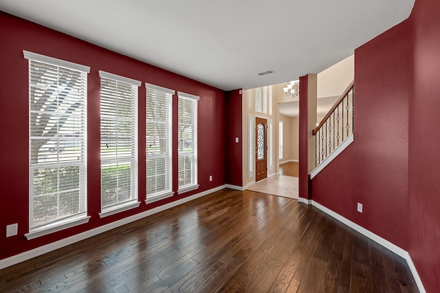 foyer entrance featuring wood-type flooring and an inviting chandelier