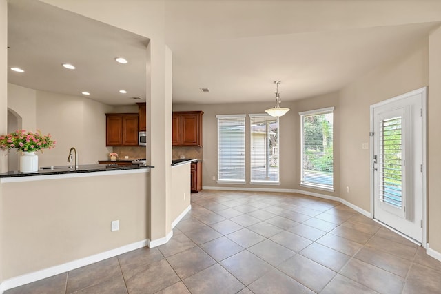 kitchen with pendant lighting, light tile patterned flooring, and sink