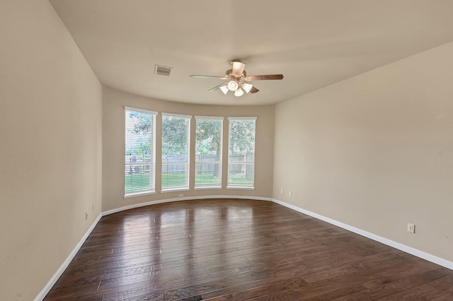 spare room with dark hardwood / wood-style flooring and ceiling fan