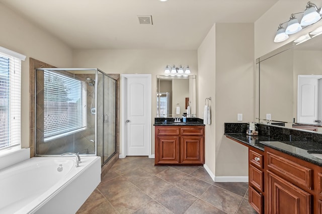 bathroom with vanity, tile patterned flooring, and plus walk in shower