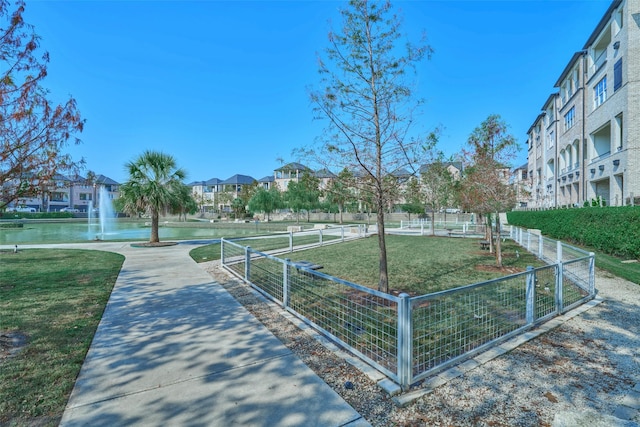 view of home's community featuring a lawn and a water view