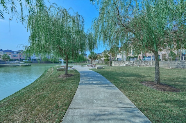 view of home's community with a water view and a yard