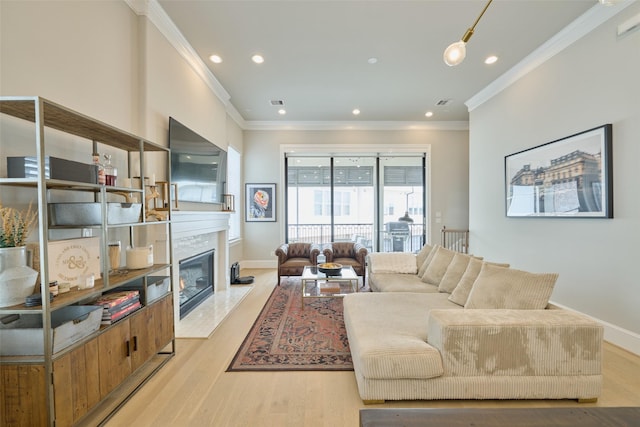 living room with a fireplace, crown molding, and light hardwood / wood-style flooring