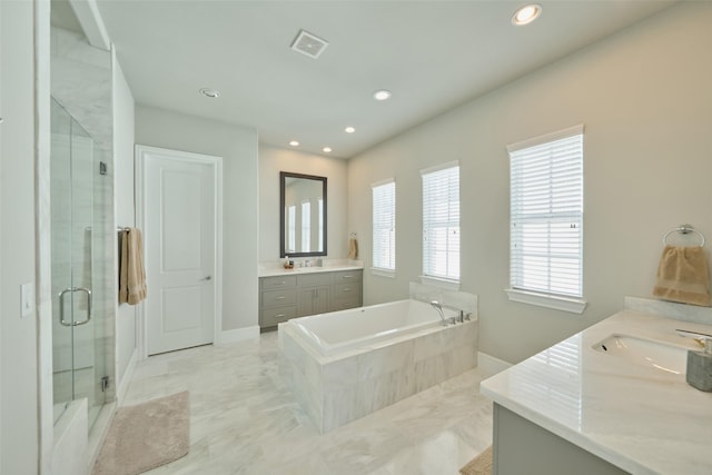 bathroom featuring vanity and independent shower and bath