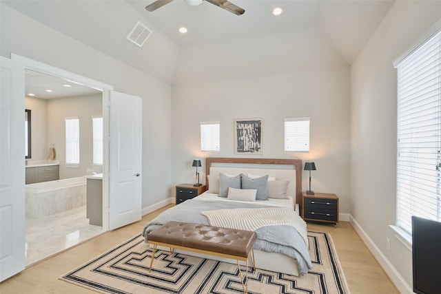 bedroom with ceiling fan, connected bathroom, vaulted ceiling, and light wood-type flooring