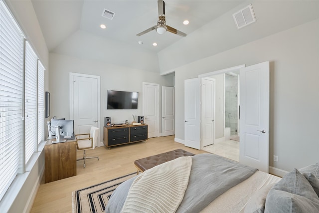 bedroom with ensuite bathroom, two closets, lofted ceiling, ceiling fan, and light hardwood / wood-style flooring