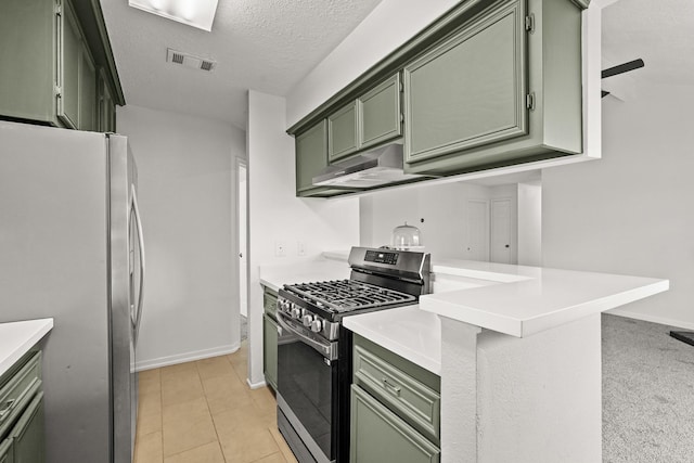 kitchen with green cabinetry, a textured ceiling, light colored carpet, kitchen peninsula, and stainless steel appliances