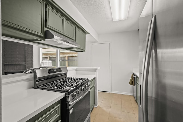 kitchen featuring light tile patterned flooring, a textured ceiling, appliances with stainless steel finishes, and green cabinetry