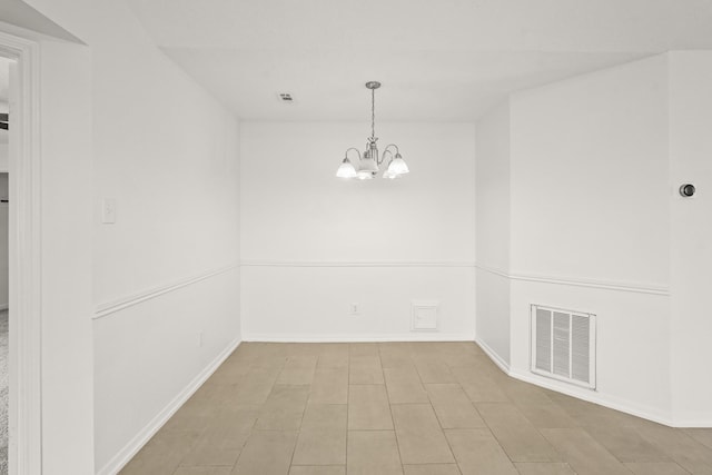 unfurnished room featuring a chandelier