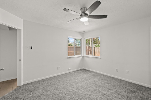 unfurnished room featuring a textured ceiling, carpet floors, and ceiling fan