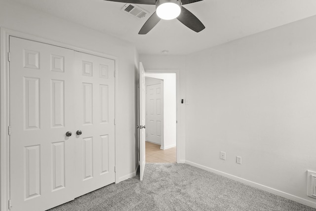 unfurnished bedroom with light carpet, a closet, and ceiling fan