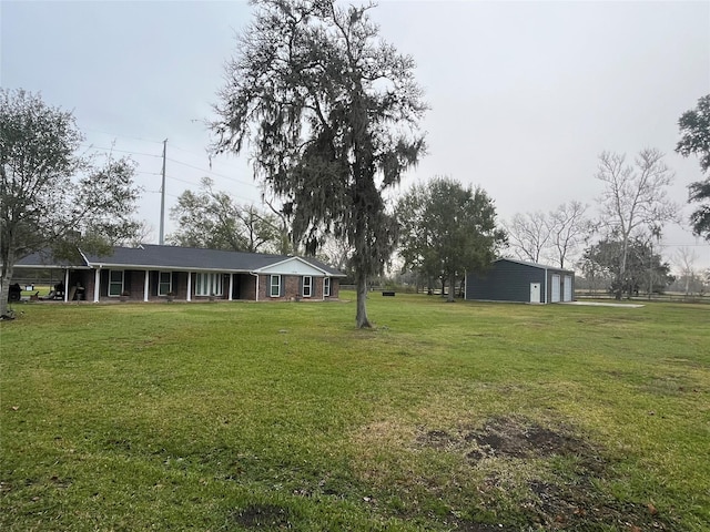 view of yard with a garage and an outbuilding