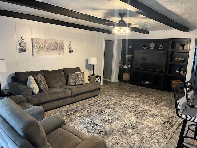 living area featuring brick floor, ceiling fan, a textured ceiling, and beam ceiling