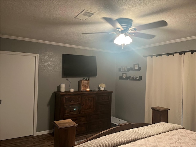 bedroom with a textured ceiling, dark wood-type flooring, visible vents, and crown molding