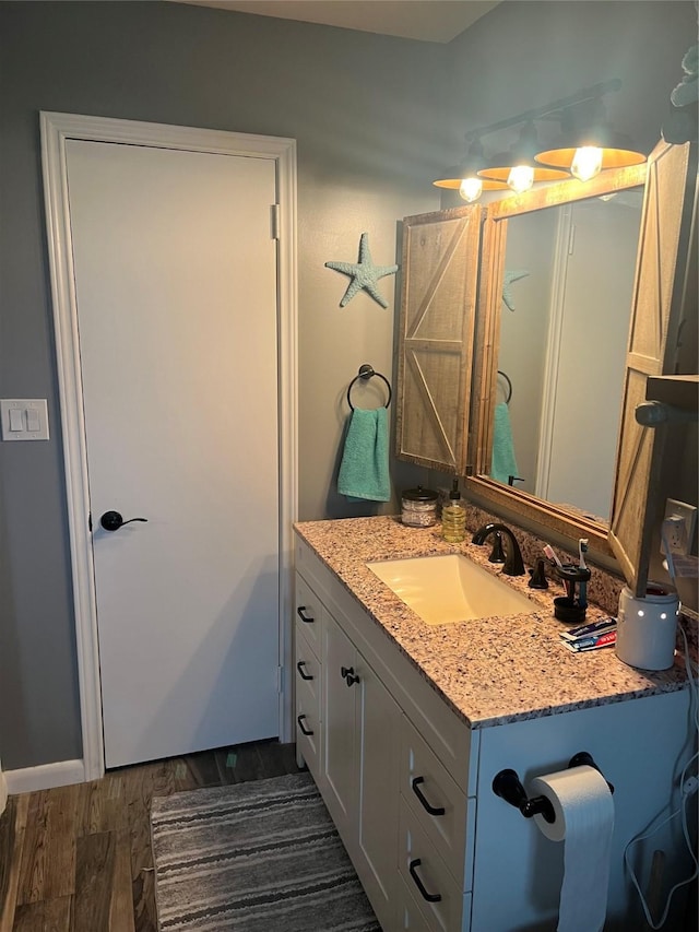 bathroom with wood finished floors and vanity