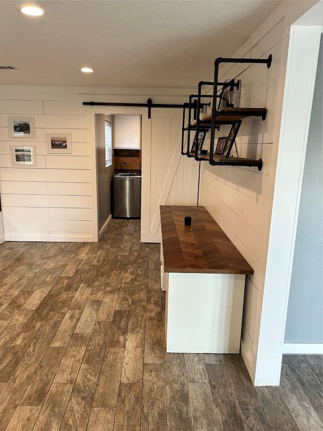 hall with a barn door and dark hardwood / wood-style floors