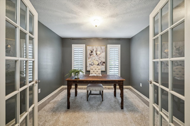 carpeted office space featuring a textured ceiling and french doors