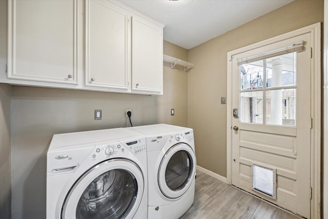 laundry area featuring washing machine and dryer and cabinets