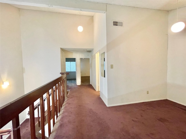 hall featuring dark colored carpet