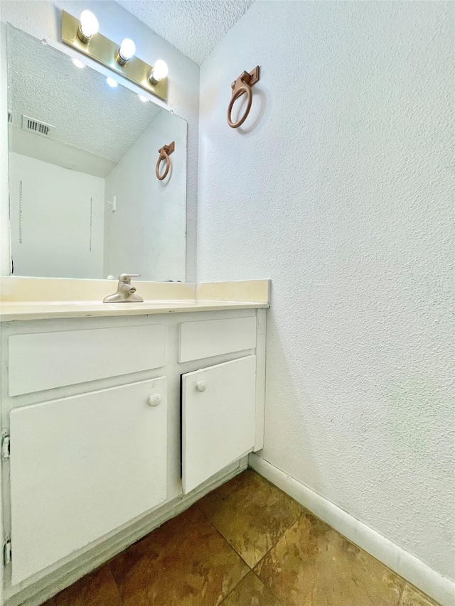 bathroom featuring a textured ceiling and vanity