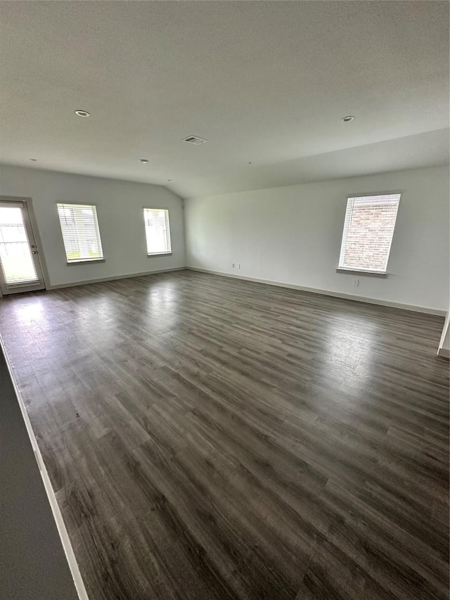 unfurnished room with dark hardwood / wood-style flooring and lofted ceiling