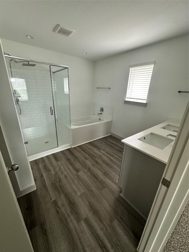 bathroom with hardwood / wood-style floors, vanity, and separate shower and tub