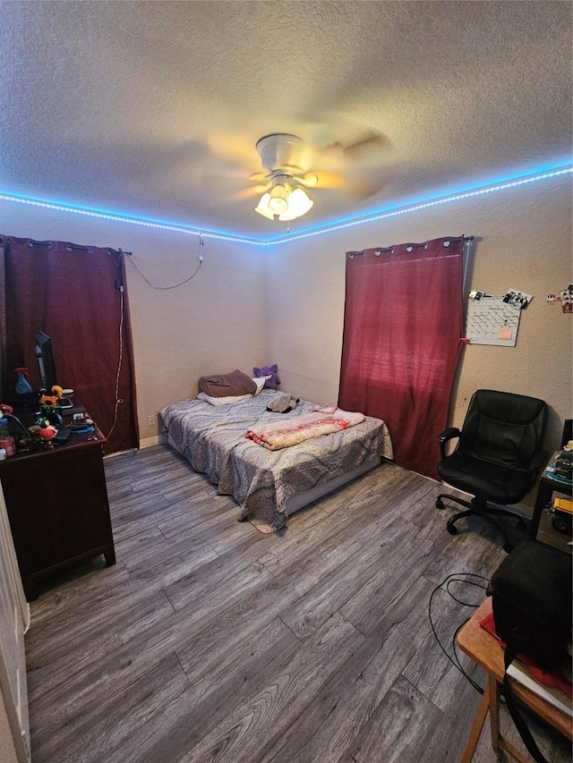 bedroom featuring hardwood / wood-style floors, ceiling fan, and a textured ceiling