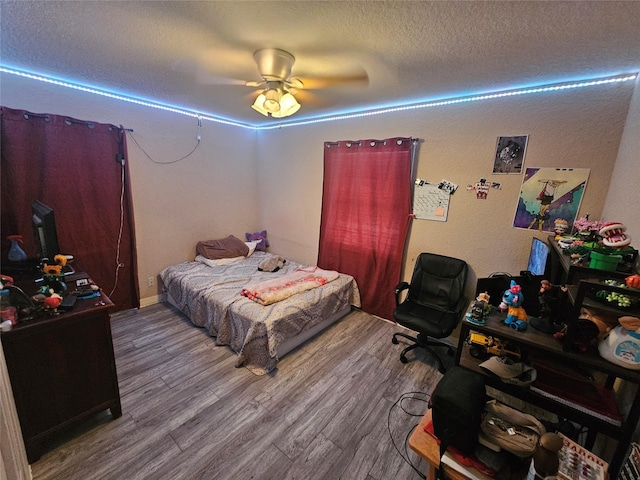 bedroom featuring wood-type flooring, a textured ceiling, and ceiling fan