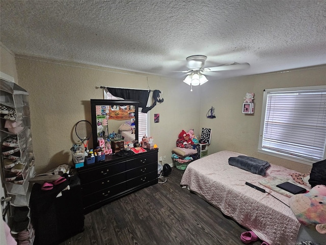 bedroom with ceiling fan, dark hardwood / wood-style floors, and a textured ceiling