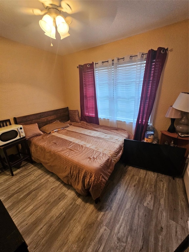 bedroom with hardwood / wood-style floors and ceiling fan